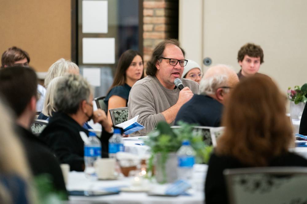 Man asks a question through a microphone at the event